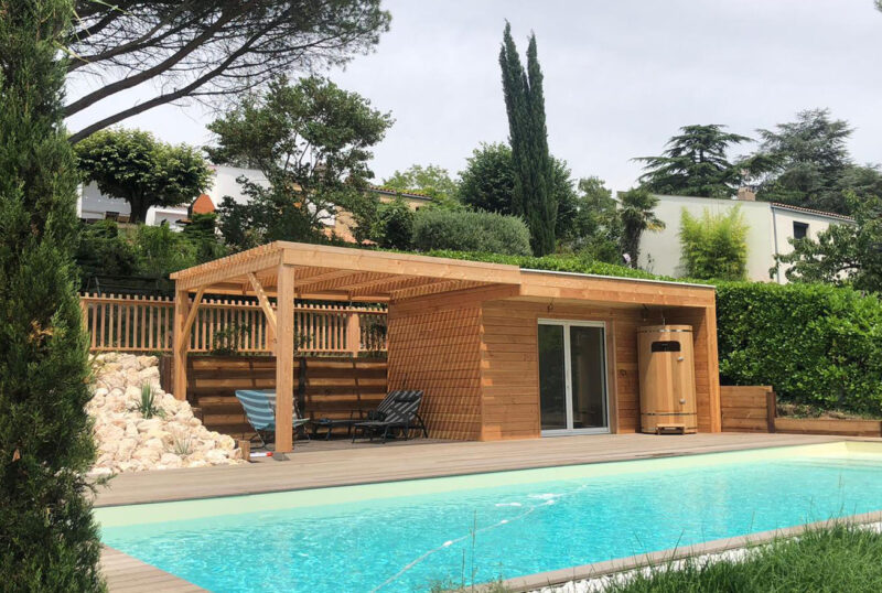 Pool house en bois aménagé au bord d’une piscine